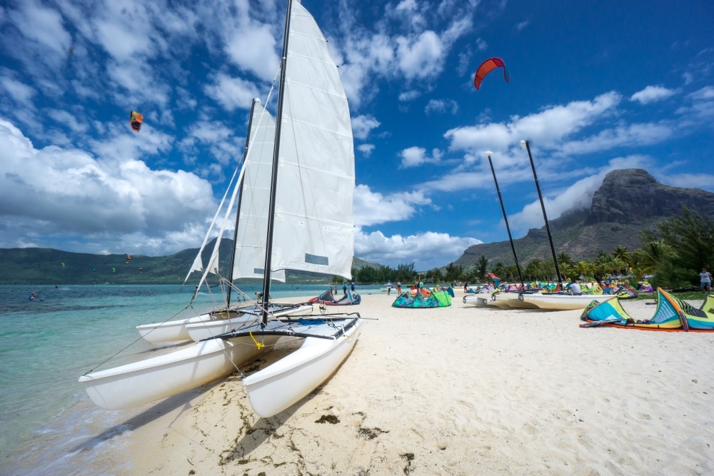 a beach with sailing boats and kites
